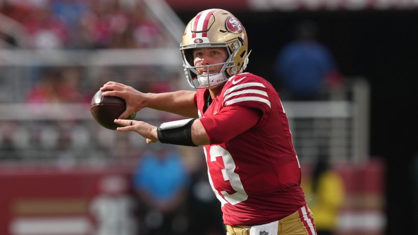 Brock Purdy throws on the run vs the Broncos.