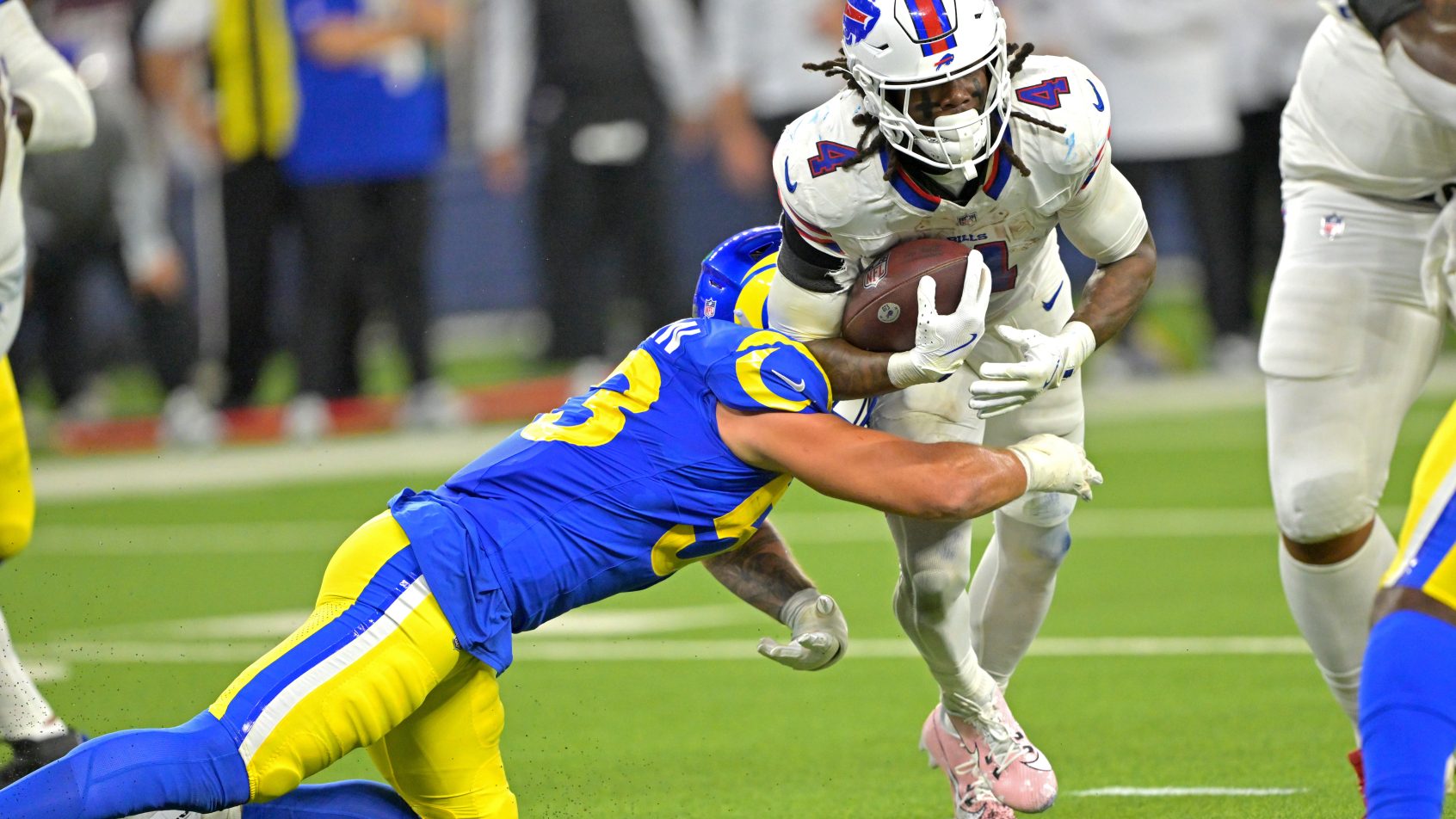 James Cook III running with the ball and fumbling
