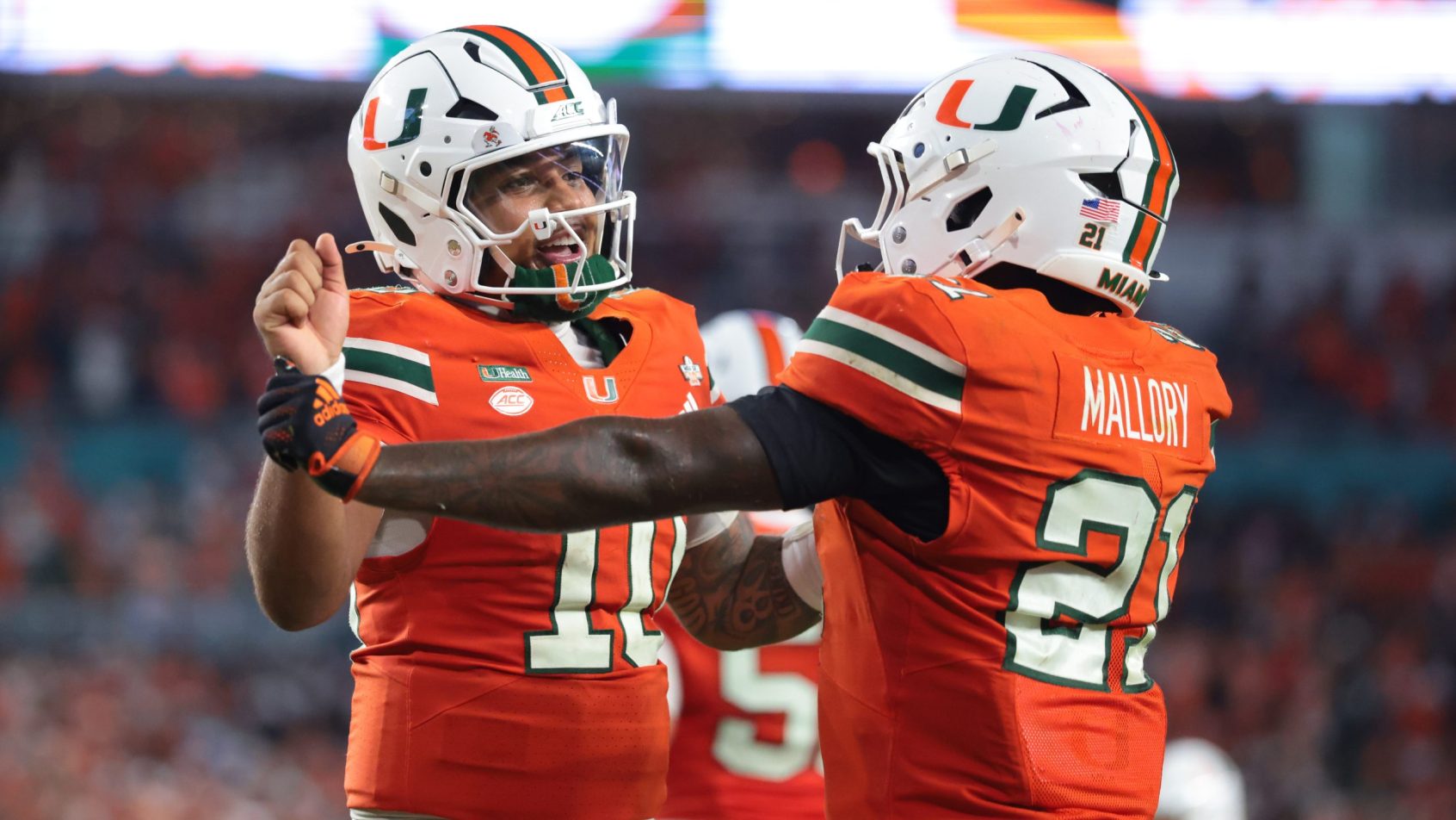 Darian Mensah celebrates a Miami touchdown with his teammate.