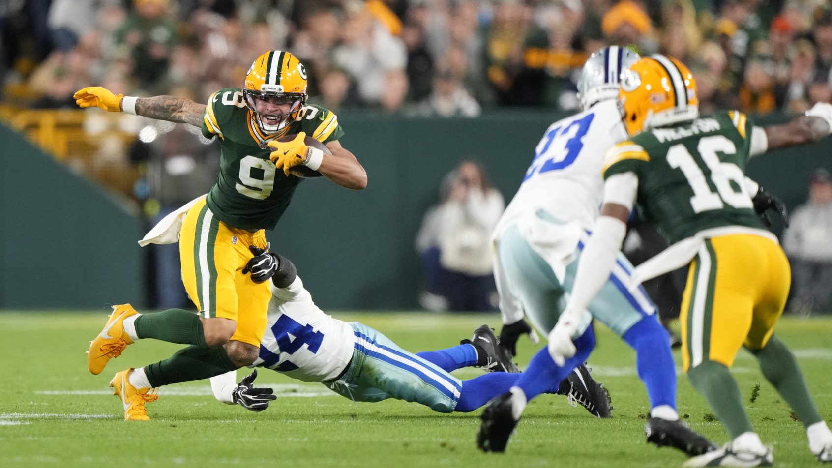 Christian Watson runs against the Dallas Cowboys at Lambeau Field