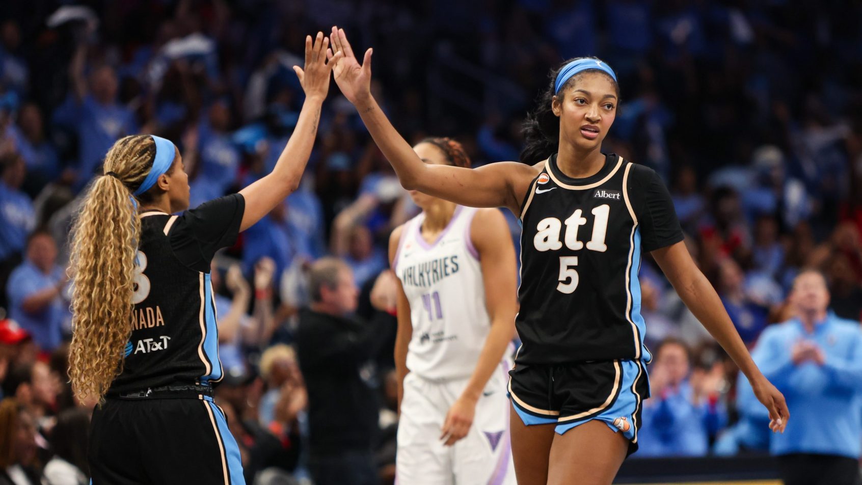 Angel Reese high-fives a teammate after a bucket in the WNBA Finals.