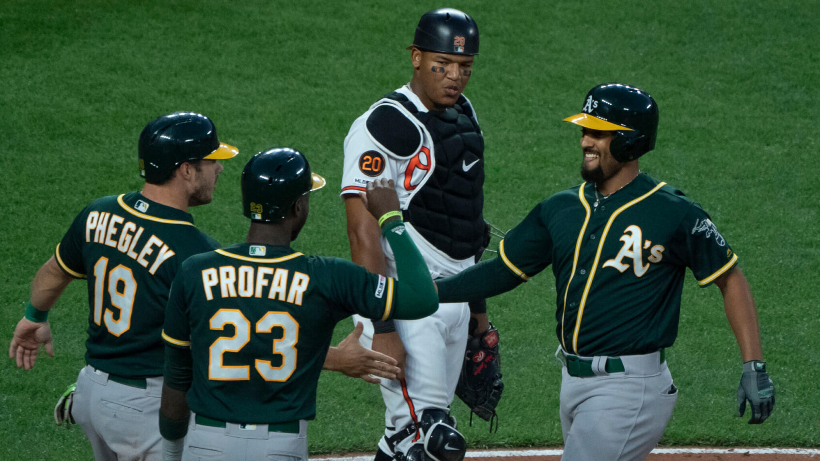 Oakland players celebrating at home plate.