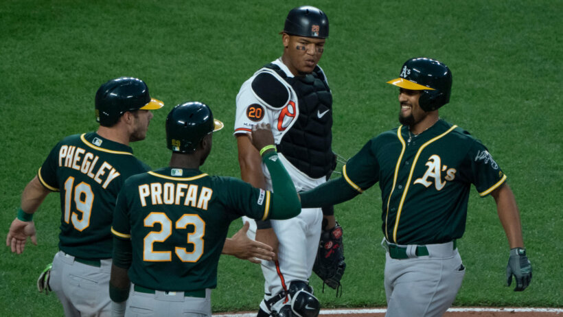 Oakland players celebrating at home plate.