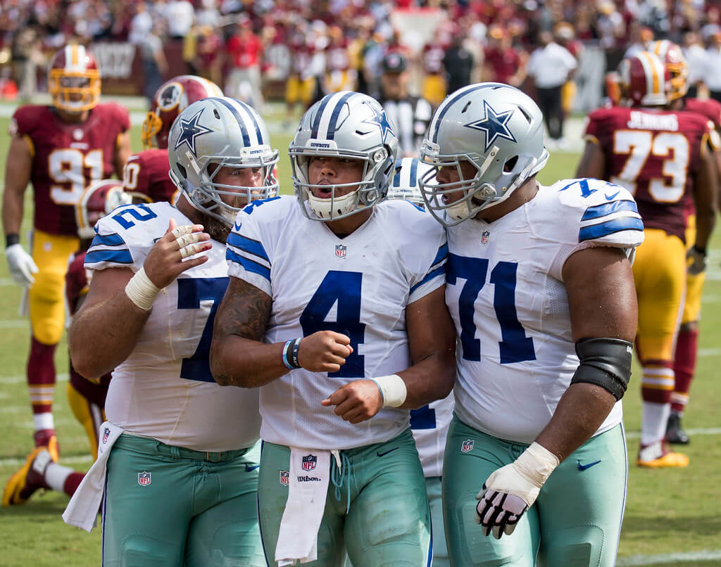 Dak Prescott celebrating with his offensive linemen after scoring a TD