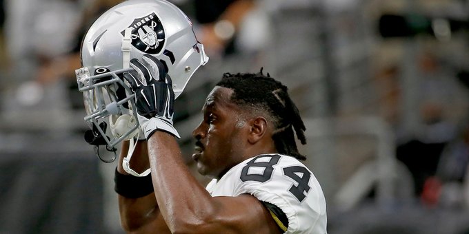 Antonio Brown strapping on his Raiders helmet