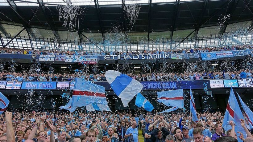 Manchester United fans celebrating a soccer game at Etihad Stadium