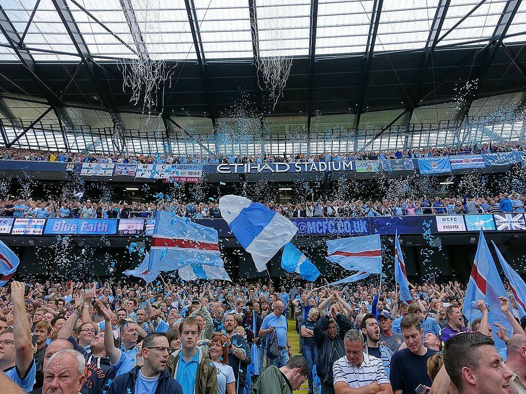 Manchester United fans celebrating a soccer game at Etihad Stadium