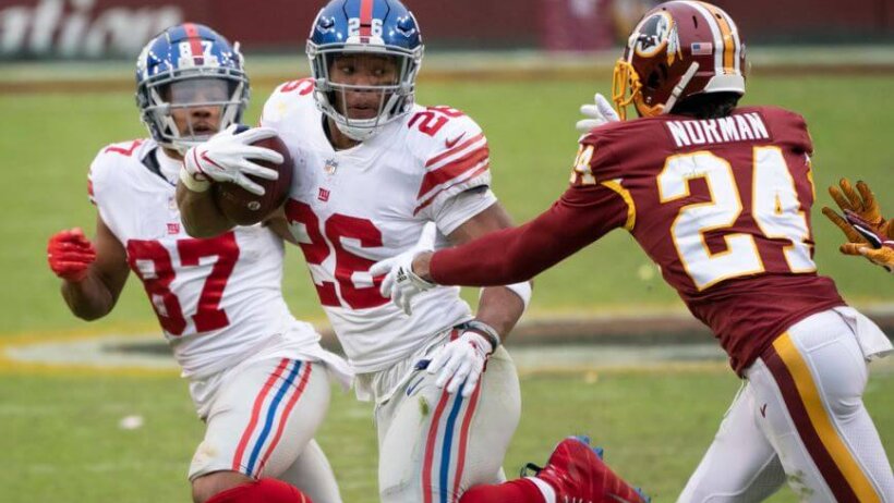NY Giants RB Saquon Barkley eludes Josh Norman of Washington.