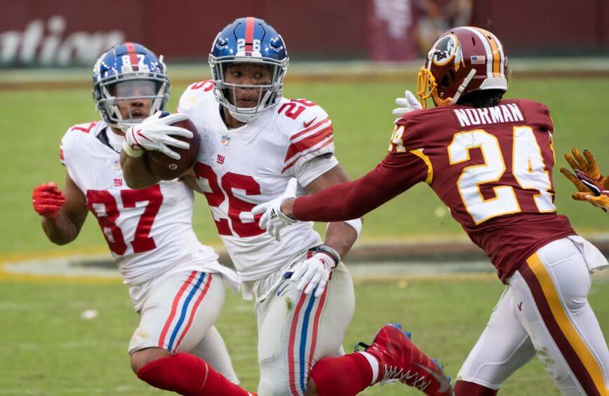NY Giants RB Saquon Barkley eludes Josh Norman of Washington.