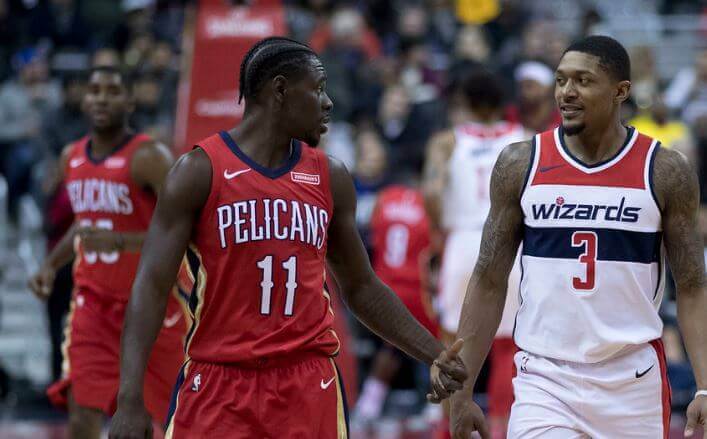 Pelicans guard Jrue Holiday talking to Wizards guard Bradley Beal on the court.