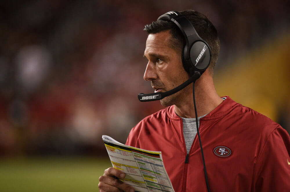 Kyle Shanahan checking his play sheet.