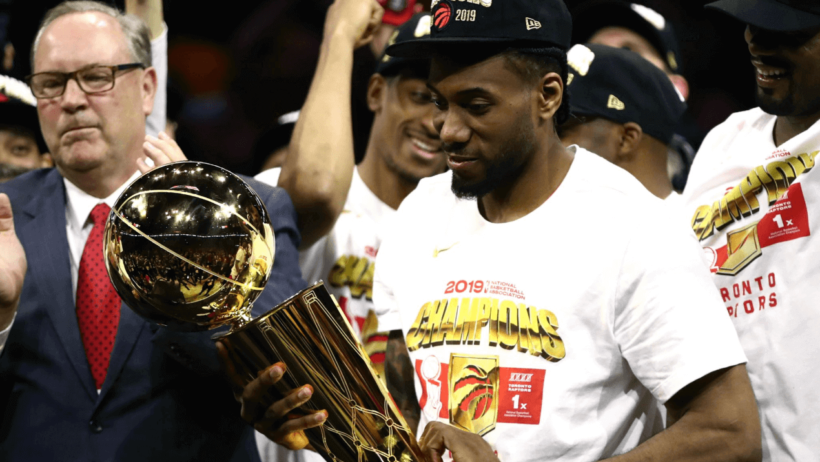 Kawhi Leonard holding Larry O'Brien Trophy.