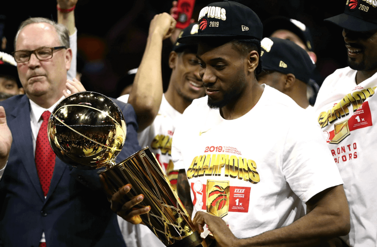 Kawhi Leonard holding Larry O'Brien Trophy.