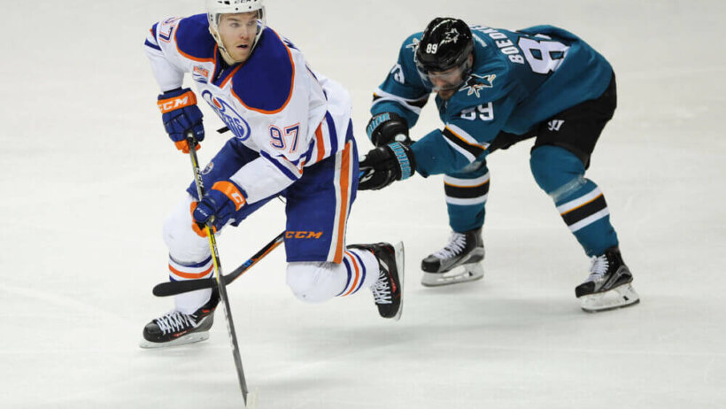 Connor McDavid stickhandles away from a Sharks defender