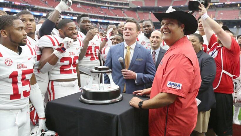 Head coach Matt Luke of the Ole Miss Rebels celebrating with his team.