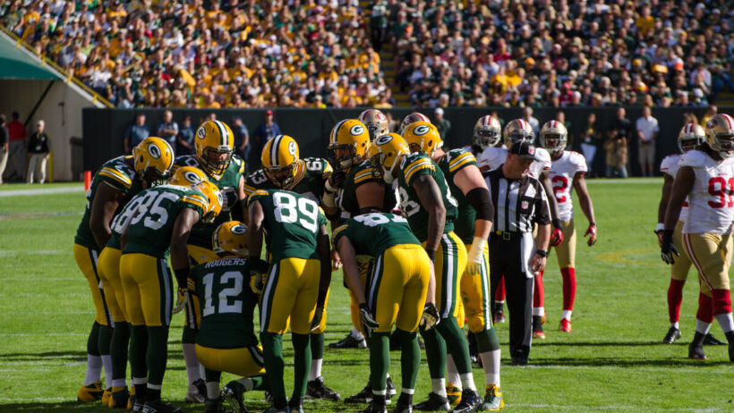 Packers huddling on the field