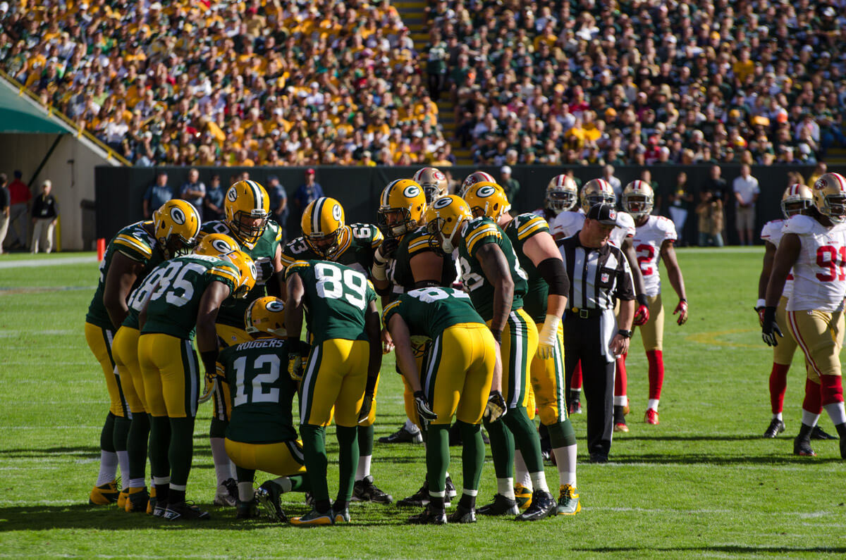Packers huddling on the field