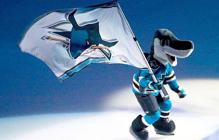 San Jose Sharks mascot skating with a team flag.
