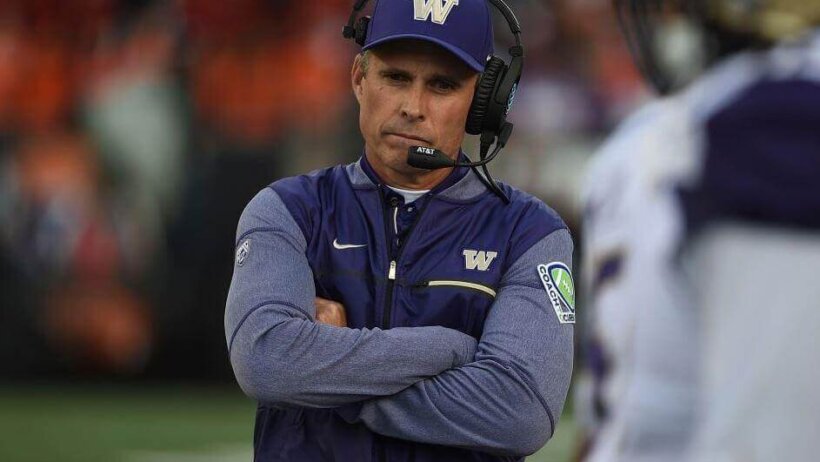 Washington coach Chris Petersen arms folded on sideline.