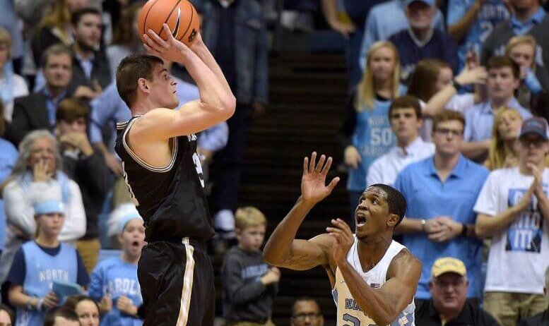 Wofford guard Fletcher Magee skies above UNC's Kenny Williams to shoot a jumper.