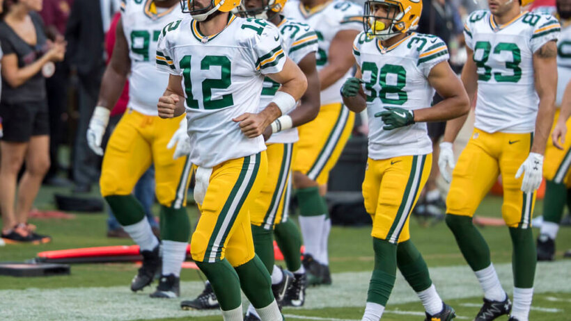 Aaron Rodgers and the Green Bay Packers run onto the field.
