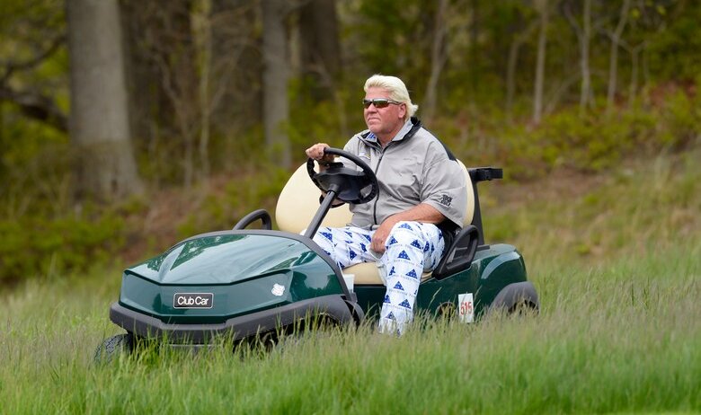 John Daly drives in a golf cart.