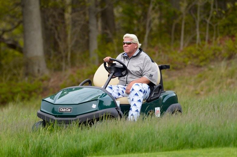John Daly drives in a golf cart.