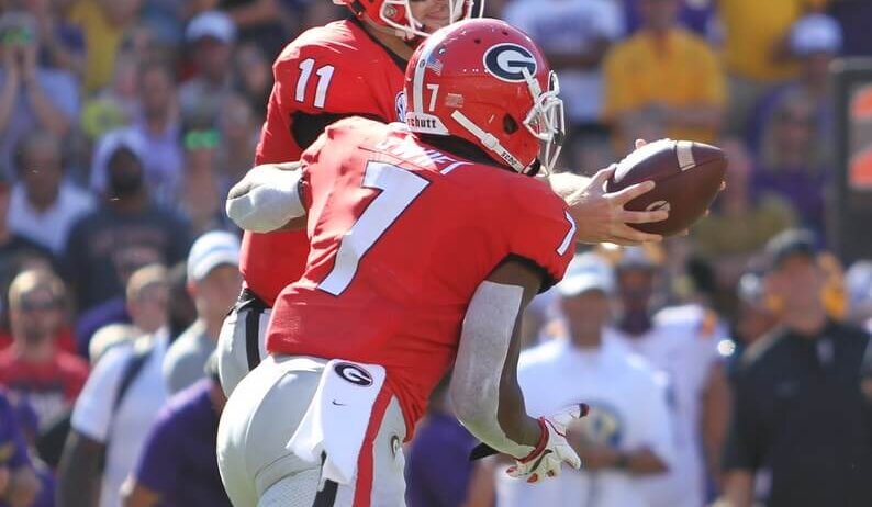 Jake Fromm hands the ball off