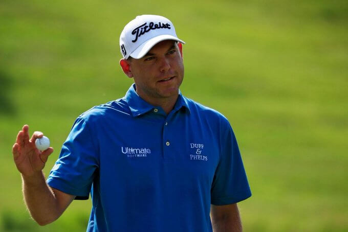 Bill Haas holding a golf ball in a blue shirt