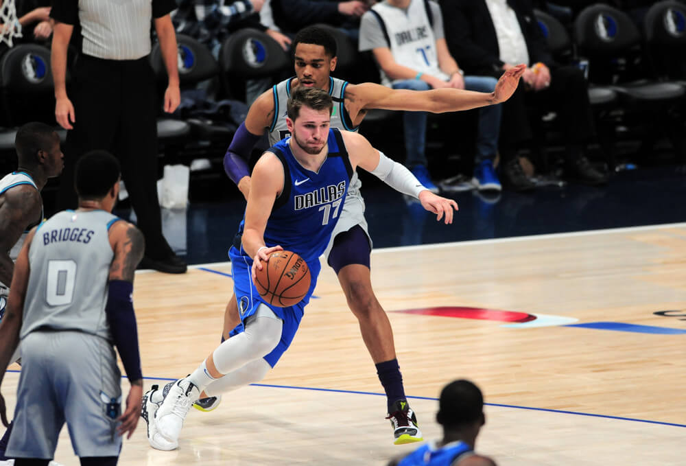Luka Doncic dribbling around defender