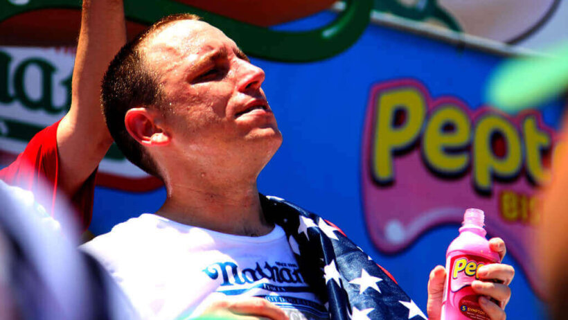 Joey Chestnut posing with titlle belt.