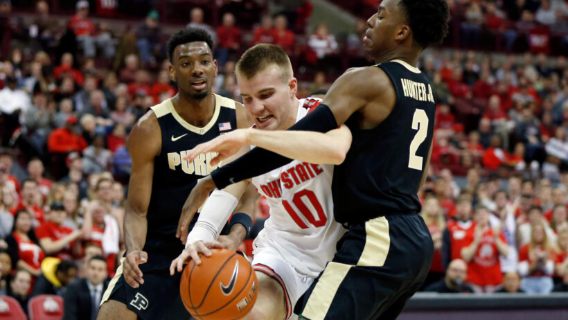 Justin Ahrens dribbling between two defenders