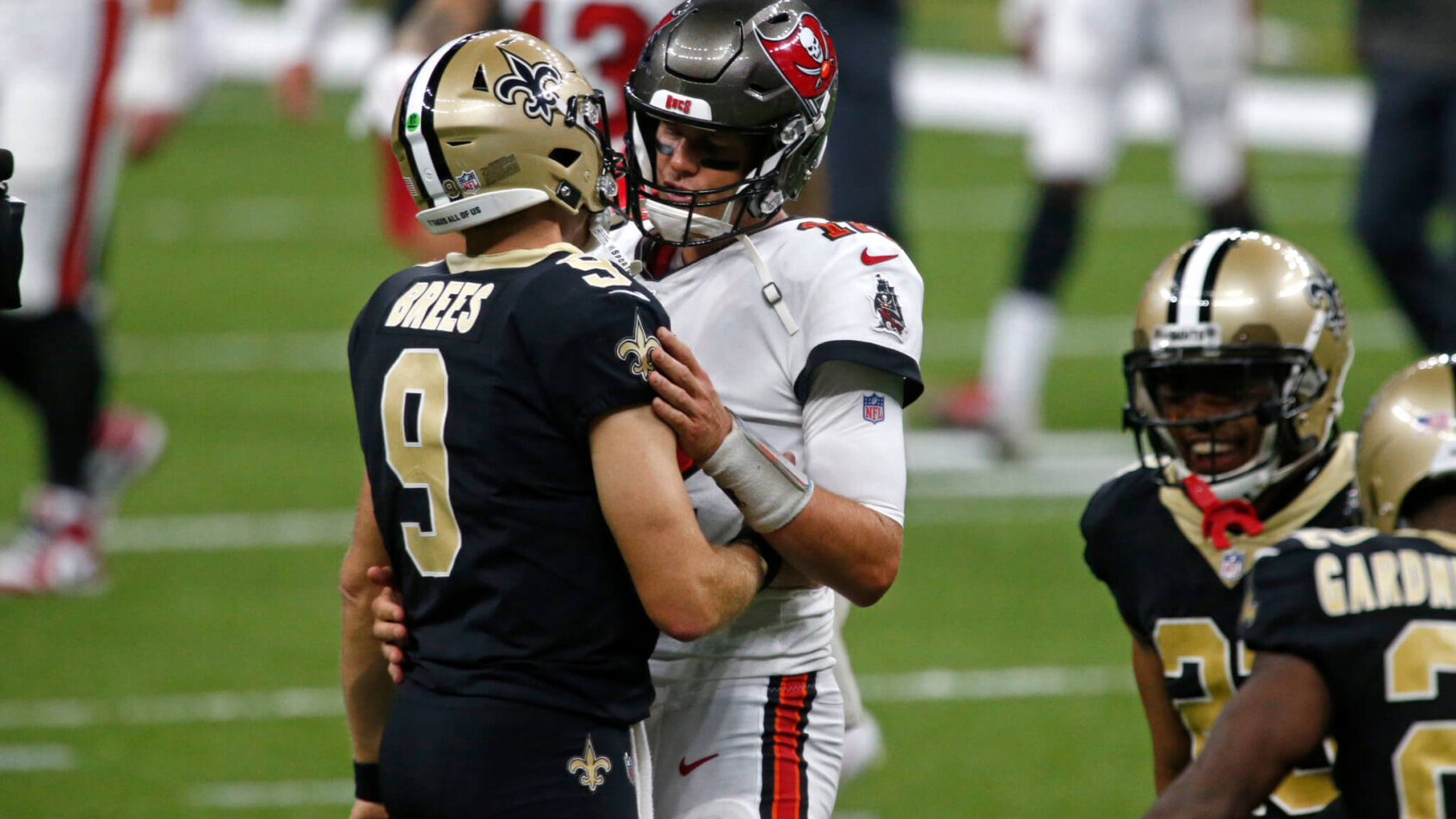 New Orleans Saints quarterback Drew Brees and Tampa Bay Buccaneers quarterback Tom Brady hugging on the field after a game.