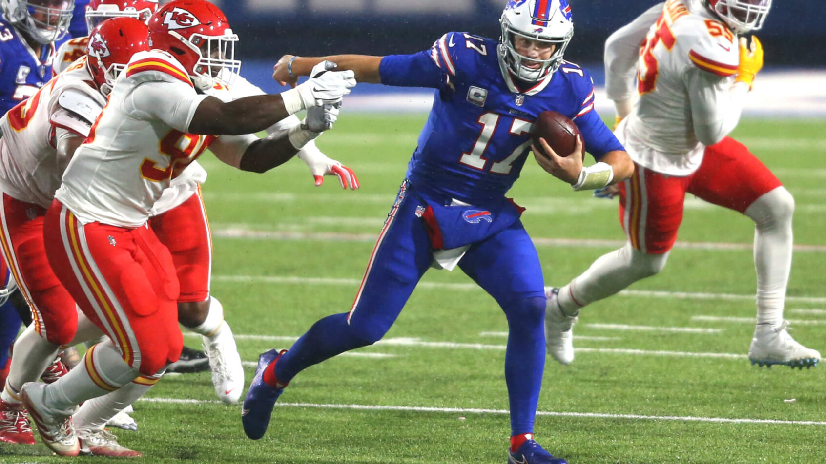 Buffalo Bills quarterback Josh Allen carrying the ball during an NFL game.