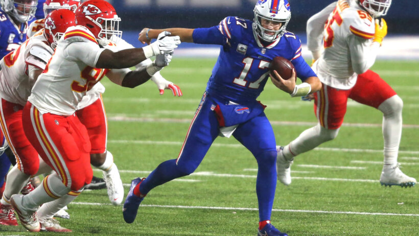 Buffalo Bills quarterback Josh Allen carrying the ball during an NFL game.