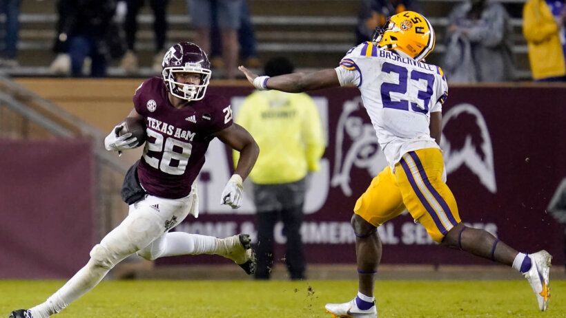 Texas A&M running back Isaiah Spiller (28) running on the field during a game as LSU linebacker Micah Baskerville (23) defends.