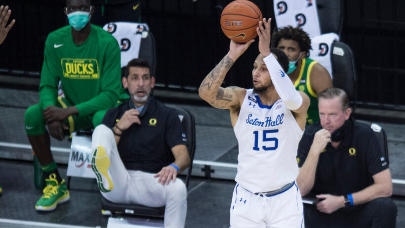 Seton Hall's Takal Molson taking a jump shot in a game in front of the Oregon bench.