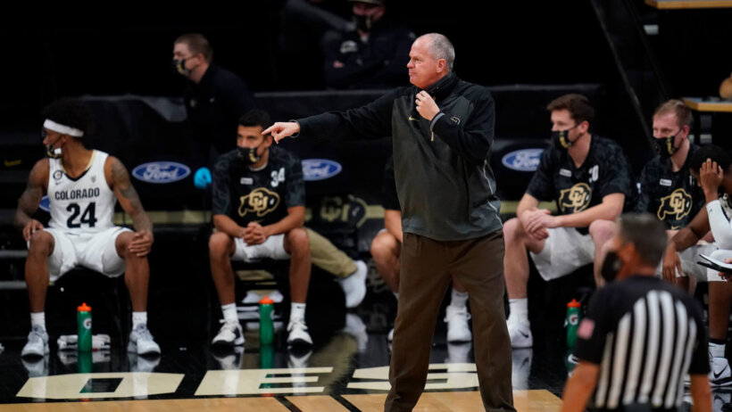 Colorado head coach Tad Boyle pointing to something happening on the court during a game.