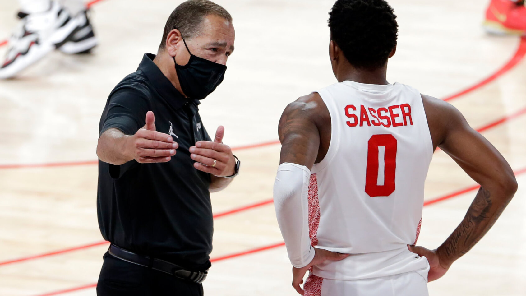 Houston head coach Kelvin Sampson talking with guard Marcus Sasser during a timeout.