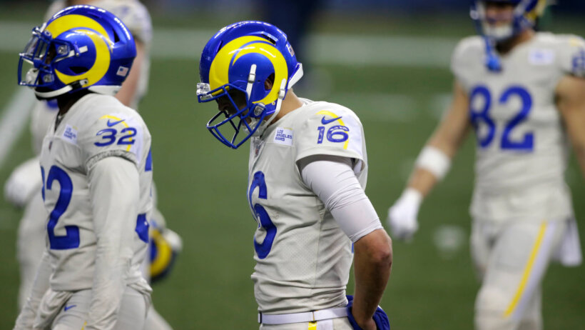 Jared Goff, hands behind back, head down walking off field
