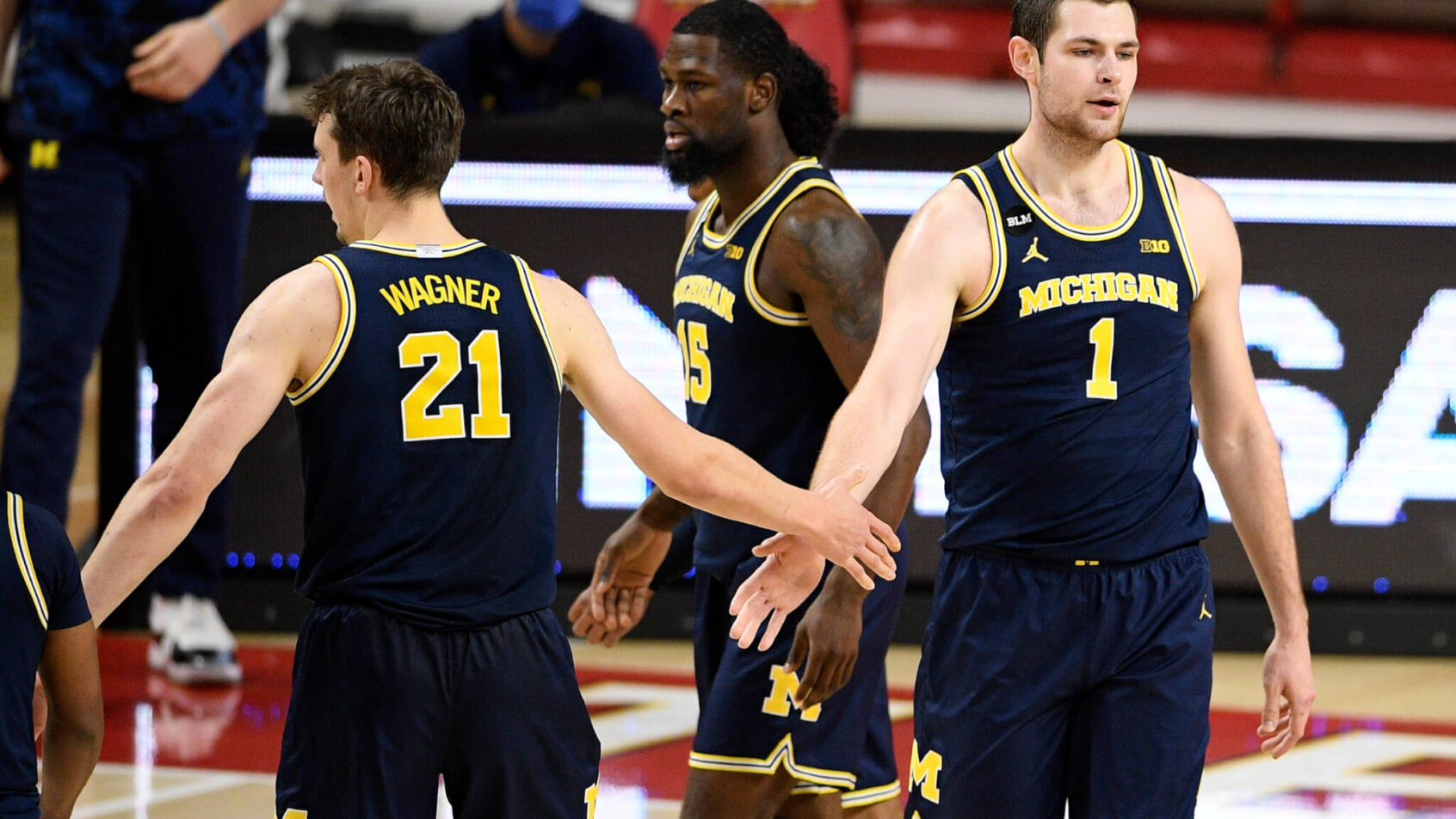 Hunter Dickinson (1) slaps hands with guard Franz Wagner