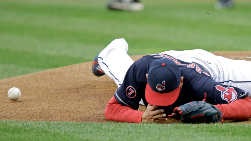 Cleveland Indians pitcher Carlos Carrasco falls to the ground