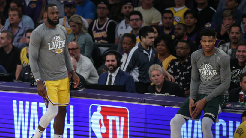 LeBron James and Giannis Antetokounmpo at scorers table