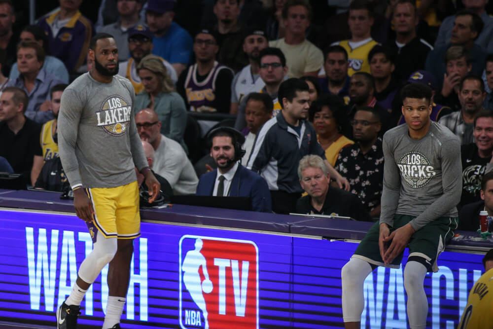 LeBron James and Giannis Antetokounmpo at scorers table