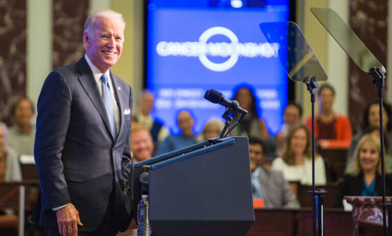 Joe Biden smiling on stage at a campaign event