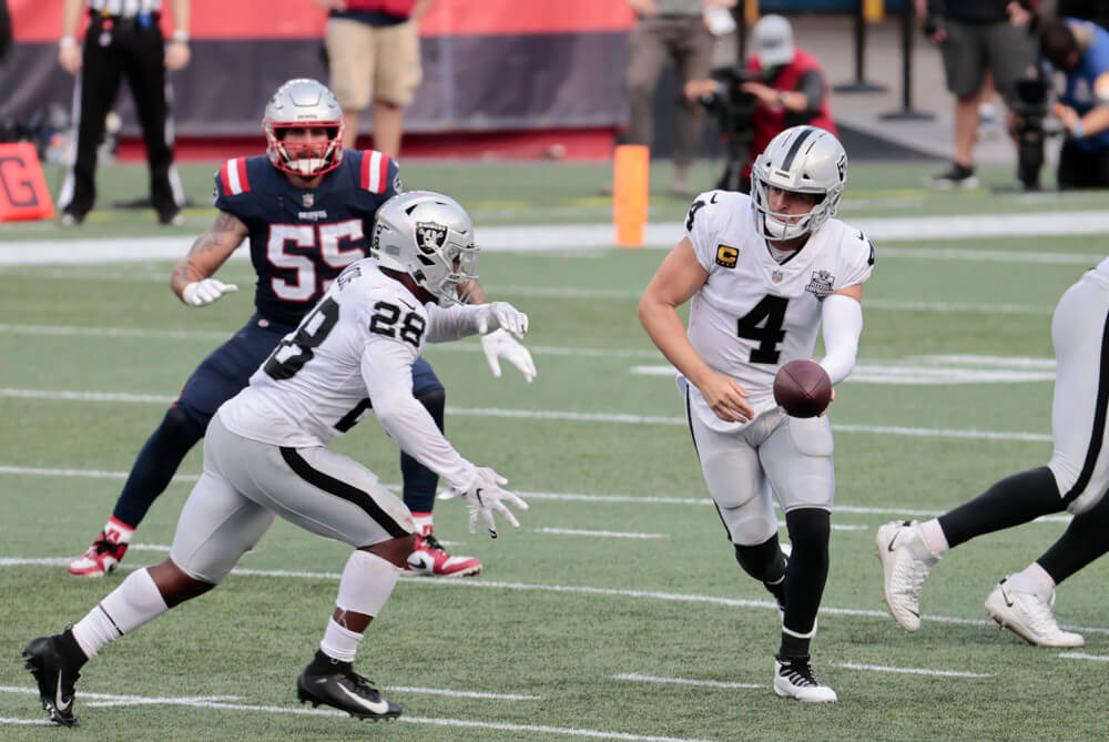 Derek Carr handing off to Josh Jacobs