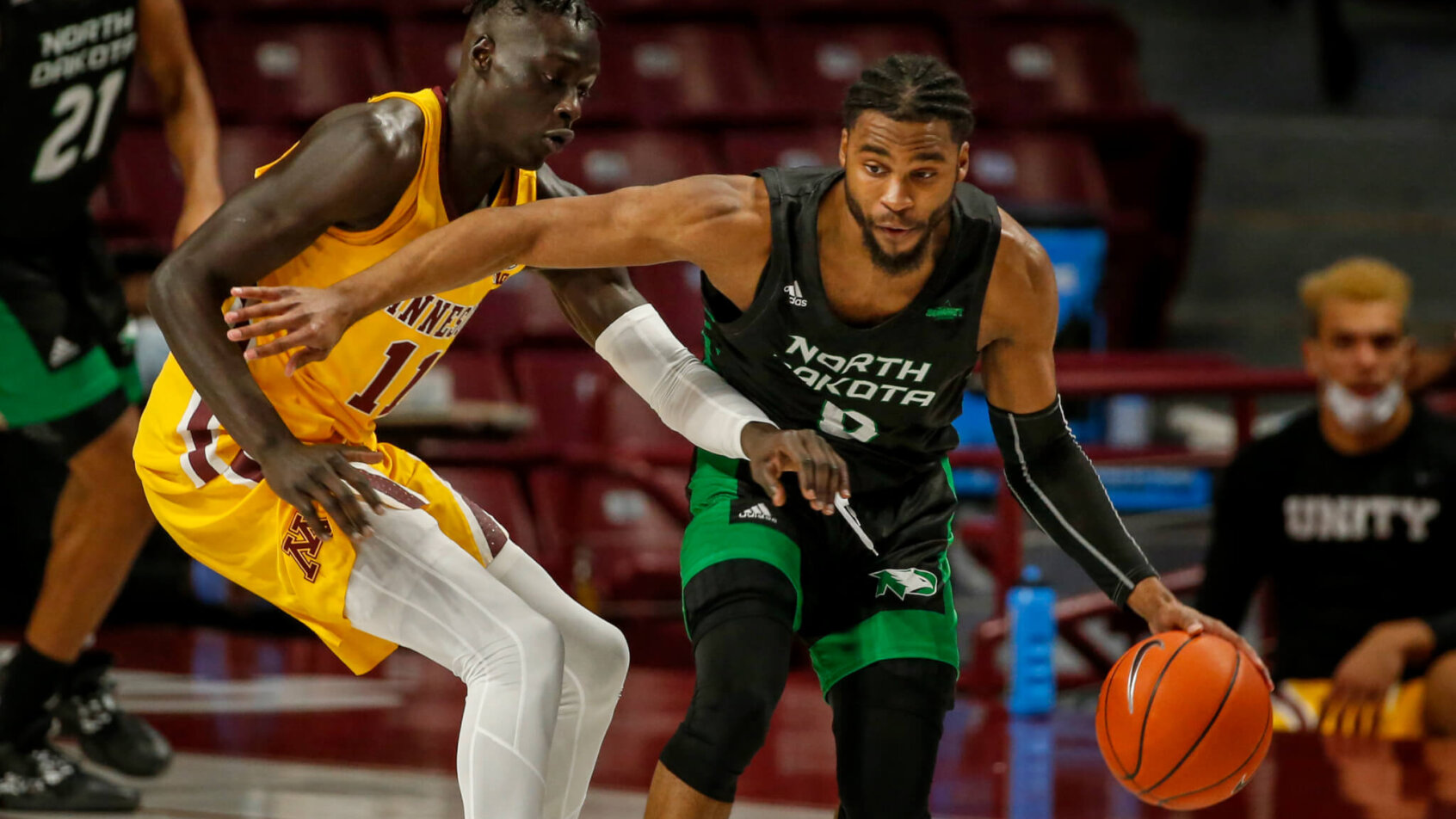North Dakota guard Caleb Nero (0) works around Minnesota guard Both Gach