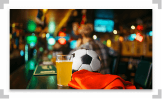 Soccer ball and glass of beer on a bar table