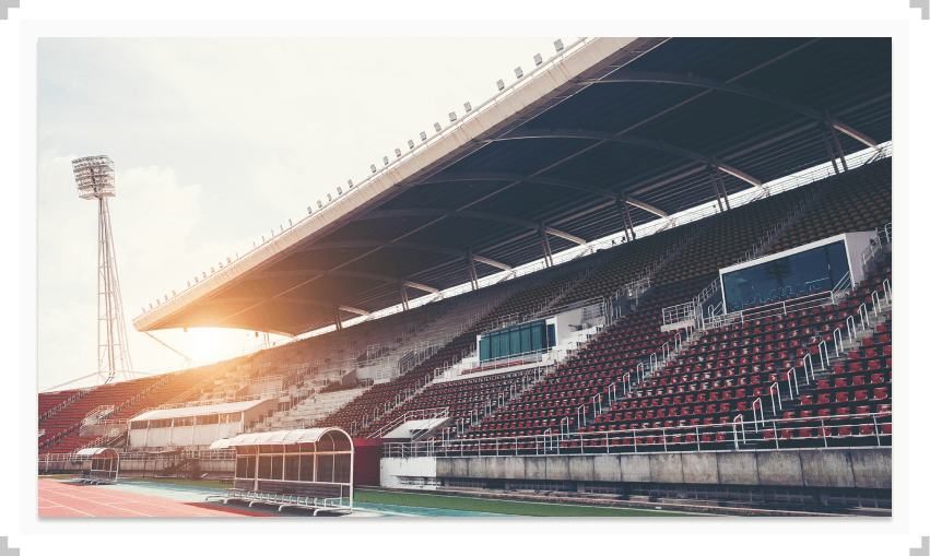 Red and white seats in a stadium with sun shining