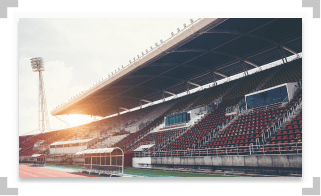 Red and white seats in a stadium with sun shining